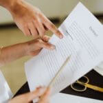 Dwie osoby analizują umowę franczyzową przy biurku w biurze