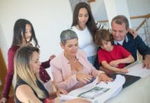 Rodzina omawia przekazanie nieruchomości z doradcą przy stole